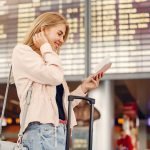 Earing and Reedeming Miles as a Frequent-Flyer with Delta SkyMiles Girl in a airport. Blonde with a documents. Lady in a black t-shirt